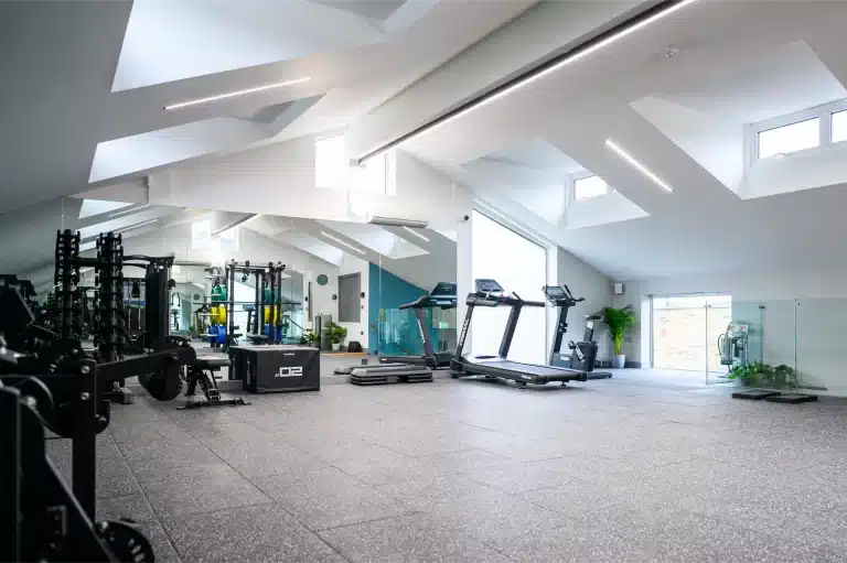 Photo of a bright, modern gym with treadmills, weight racks and exercise equipment